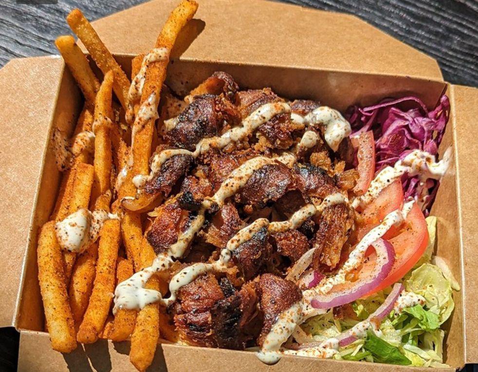 Döner box with fries, meat, salad, and white sauce